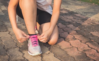 Woman tying shoelace.